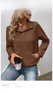 Detail eines braunen Sweatshirts mit Textur und modischem Revers mit silbernen Druckknöpfen