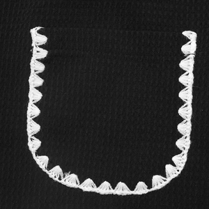 Détail macro du tissu en tweed noir avec bordure contrastée en dentelle crochetée blanche