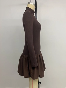 Close-up of dark brown ribbed knit dress with detailed puff hem and stitching