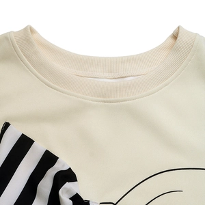 Close-up of ribbed crew neck on beige sweatshirt with black stripes and line print