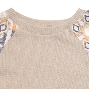 Close-up of waffle knit texture and ethnic geometric print on the raglan sleeve top