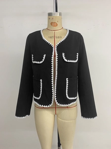 Détail de veste en tweed avec broderies ondulées blanches sur poches et bords contrastés