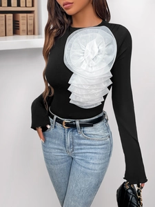 Detail of slim fit black bodysuit featuring large white 3D floral organza decoration