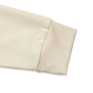 Close-up of ribbed cuffs on cream oversized sweatshirt showing knit texture details