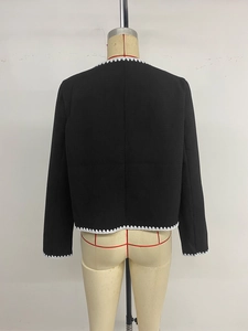 Vue arrière de la veste en tweed noir avec bordure ondulée blanche et maille texturée