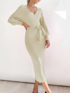 Detail view of beige knit dress featuring V-neck, lantern sleeves and a belted waistline