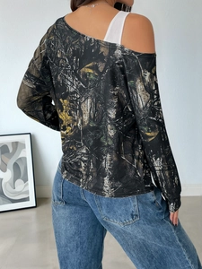 Detail of the off-shoulder cutout and forest camouflage pattern on a long-sleeved top