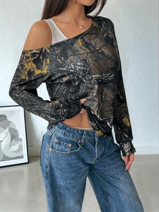 Detail showing the camouflage print texture and cold-shoulder design with straps