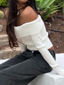 Nahaufnahme des weißen gerippten Off-Shoulder-Strickpullovers mit langen Ärmeln