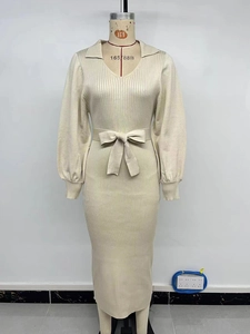 Detail of knit midi dress featuring lantern sleeves, V-neck, and tied waist belt in beige