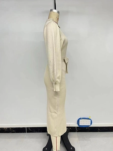 Detail view of the ribbed knit beige dress showing the belt and fitted ribbed cuffs