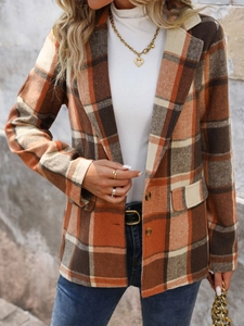 Detail of vintage plaid blazer fabric featuring notched lapels and classic brown check patterns