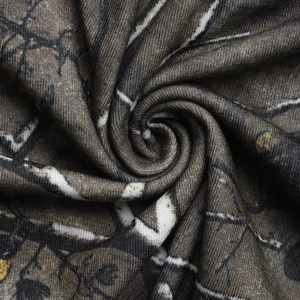Macro detail of jungle branch print fabric showing smooth texture and forest pattern