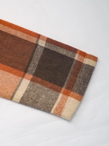 Detail of plaid coat cuff with orange and brown twill weave fabric texture