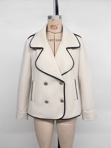 Detail of the light beige wool coat showing black contrast piping and double-breasted buttons