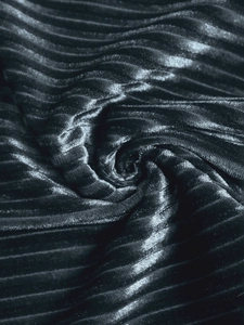 Gros plan sur la texture rayée verticale d'un pantalon en velours noir à l'éclat doux