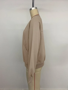 Detail view of beige oversized casual jacket with ribbed cuffs and side slant pockets