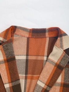 Detailed view of the retro orange plaid pattern and notch lapel of the jacket