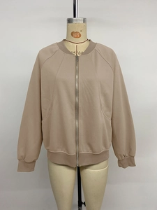 Detail view of the ribbed knit collar and full zipper on a beige bomber jacket