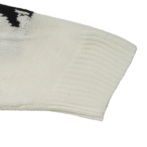 Detail of white knit sweater cuff with ribbed texture and black jacquard pattern