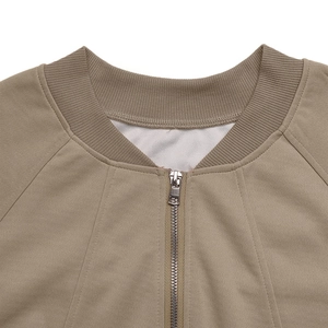 Detail of khaki zip-up jacket featuring ribbed knit collar and metal zipper closure