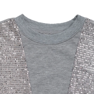 Detailed view of silver sequin stitching and ribbed neckline on a grey sweatshirt