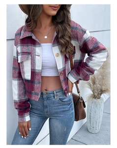 Detail of red plaid cropped shirt jacket featuring front flap pockets and textured buttons