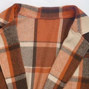 Close-up of retro plaid blazer for women featuring orange brushed fabric and notch lapels