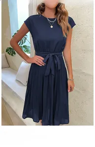 Detailed view of the pleated skirt hem and tie-waist bow on a navy sleeveless dress
