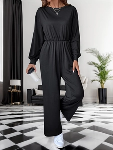 Detail of waist design and soft fabric on the black long sleeve wide-leg jumpsuit