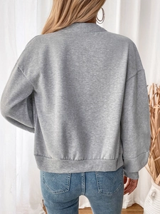 Rear view of a grey fleece zip-up sweatshirt with elastic hem and cuffs on a female model