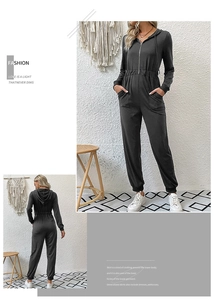 Detail view of the gray hooded jumpsuit showing front zipper and elastic waist design