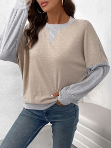 Close-up of crewneck sweatshirt with triangular stitching and contrasting grey sleeves