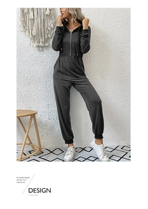 Detail of dark gray hooded jumpsuit featuring metal zipper and drawstring waist