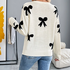 Women's crewneck long sleeve knit sweater featuring black bow jacquard patterns on beige