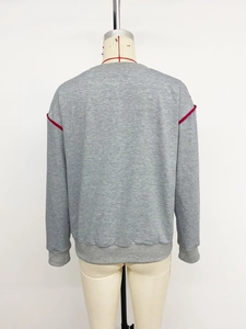 Back view of gray crewneck sweatshirt featuring red contrast piping on shoulders