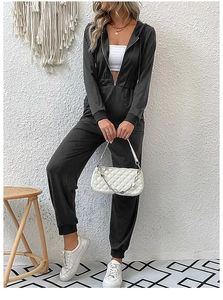 Detail of black long sleeve jumpsuit featuring front metal zipper and elastic waistline