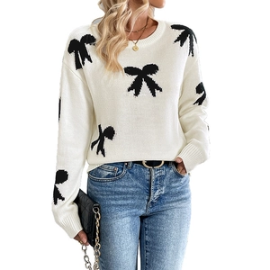 Women's white crewneck knit sweater with black bow jacquard pattern and long sleeves