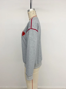 Close-up of grey sweatshirt with red heart embroidery and sleeve stripes on mannequin