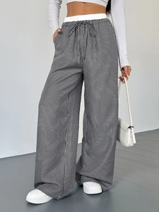 Dettaglio della vita alta elastica con coulisse sui pantaloni a righe bianche e nere