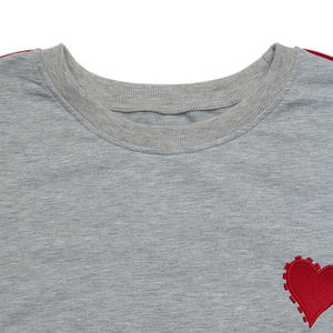 Detail of round neckline and red heart embroidery on gray long-sleeve sweatshirt