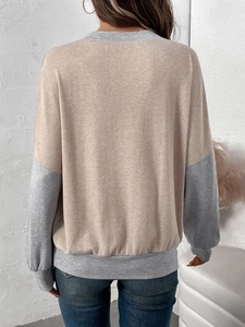 Detail of loose-fit color-block sweatshirt featuring khaki and grey contrast stitching