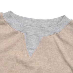 Macro shot of ribbed crew neck and grey triangle stitch detail on beige cotton sweatshirt