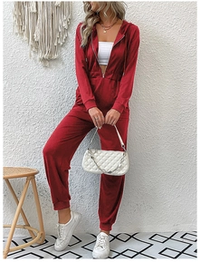 Macro shot of burgundy hooded jumpsuit with front zipper detail and soft knit fabric texture