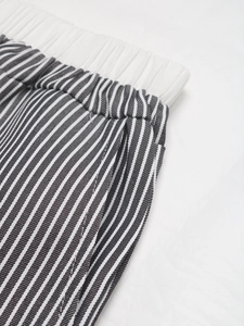 Dettaglio dei pantaloni a righe a vita alta con fascia elastica e trama del tessuto
