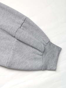 Detailed close-up of premium fleece fabric sleeve and ribbed cuff on a gray jacket