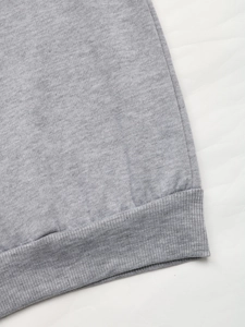 Detailed shot of the ribbed hem and stitching on a grey fleece sweatshirt for women