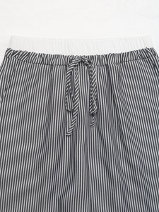 Dettaglio dei pantaloni a righe a vita alta con elastico in vita e coulisse