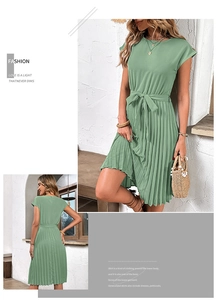 Detail of sage green pleated dress featuring short sleeves and matching waist tie belt