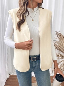 Detail of cream fleece vest paired with a white ribbed shirt and denim jeans in studio